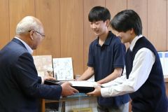 齊藤会長（左）からタオルの寄贈を受けた田中会長（中央）と小野塚副会長（右）
