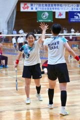 【女子団体戦北北海道決勝・旭川商―旭川実】第２ゲーム終盤、競り合いからポイントを奪い、タッチを交わす旭川商の藤川千愛（左）＝金野和彦撮影
