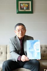 ２０年ぶりに刷新したルールブックを手にする小島理事長