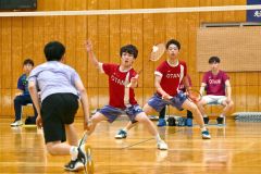 【男子個人戦ダブルス北北海道決勝】第１ゲーム、果敢に攻める帯大谷の竹村怜斗（赤色ユニホーム、左手前）。同、右後方は木村友翔（金野和彦撮影）