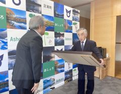 （写真左から）渡辺町長から勲記と勲章を受け取った高木さん