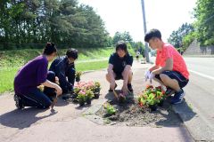 高校前の坂で花を植える生徒