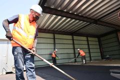 炎天下の中、空調ベストなどを身につけ舗装工事を行う東日本冨士新道路の作業員