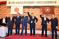 登壇してガンバローコールを行う支部役員ら（右から４人目が中川支部長）
