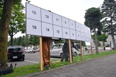 ポスター掲示場を設置する作業員ら