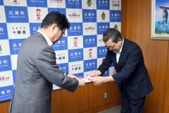 田中町長（左）に目録を手渡す山田支店長