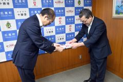 山岸教育長（左）に目録を手渡す山田支店長
