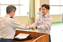 長谷川局長（左）から資格者章を受け取る職員