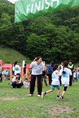 「お疲れさま！」。ゴールで参加者をハイタッチで迎える永原選手