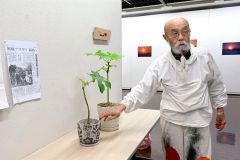 展示物の前で戦争体験を語る月下さん（金野和彦撮影）