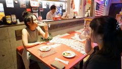 参加店の一覧が掲載されたチラシをみながら、はしご酒を楽しむ客