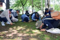 乙幡さん(右)とルーペでコケを観察する受講者ら