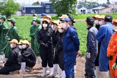 ドローンでの農薬散布を見学する生徒たち
