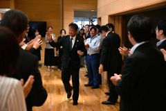 職員にハイタッチで迎えられ、初登庁する川尻村長