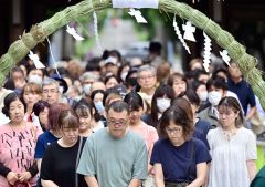 列をなし茅の輪をくぐる参拝者(塩原真撮影)