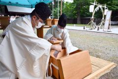 形代を木箱に収める神職(塩原真撮影)