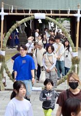列をつくり茅の輪をくぐる参拝者(6月30日、帯廣神社で。塩原真撮影)