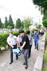 負傷者を運ぶ訓練を行う職員