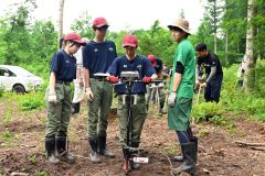 位置誘導装置を用いた植樹作業を体験する生徒