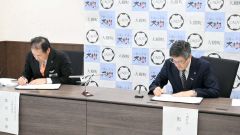 災害協定書に署名する（右から）黒川町長、富田社長