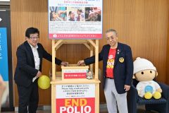 除幕しさっそく募金する（左から）月森所長と飛岡会長