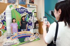 「宇宙なんちゃら　こてつくん」のフォトブースで撮影する親子ら