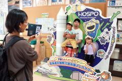 「宇宙なんちゃら　こてつくん」のフォトブースで撮影する家族連れ