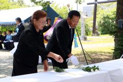 白菊を献花して手を合わせる北守会長（右）
