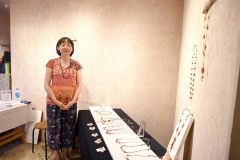 手作りのネックレスをつけてＰＲしている平松さん