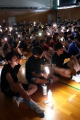 合唱発表をスマホライトの光を手に聴き入る生徒たち（６日、帯広三条高校、助川かおる通信員）