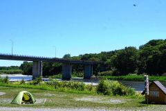 河川敷にいるクマをけん制しながらキャンパーに指示を出すドローン（右上）