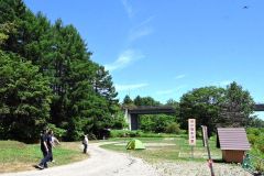 河川敷にいるクマをけん制しながらキャンパーに避難を指示するドローン（右上）