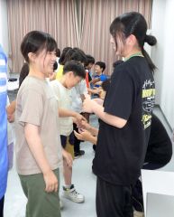 大学生（右）にお礼の手紙が渡す児童