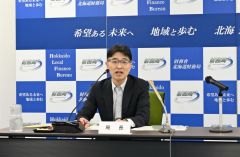 記者会見する秋田局長