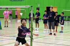 永原さん(右)が見守る中、元気よく練習する子どもたち(12日、午前11時半ごろ、芽室町総合体育館で。金野和彦撮影)