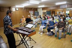 うちわを振りながら演奏を楽しむ参加者