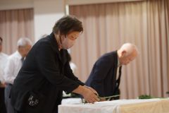 献花台に花を手向ける参列者ら