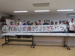 協力して完成させた横断幕を手にする高齢者と生徒たち
