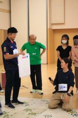 モルックのルール説明する研修生の田上さん（左）と上野美南海さん（右下）