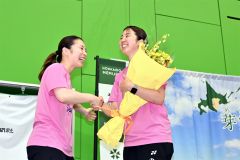 トークショーの最後に、松友美佐紀さん（左）から花束が贈られ、感激する永原さん
