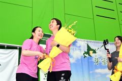 トークショーの最後に、松友美佐紀さん（左）から花束が贈られ感激する永原さん