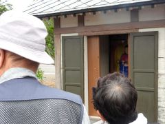 太子堂に残る弾痕を見る参加者