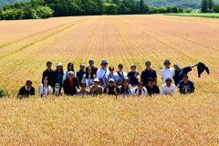 前田農産のキタノカオリ畑で記念撮影する台湾のパン職人ら