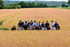 前田農産のキタノカオリ畑で記念撮影する台湾のパン職人ら