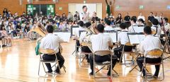 音楽隊の演奏に耳を傾ける児童ら