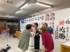 初当選し、支持者から花束を受け取る湯浅氏（２０日午後９時１５分ごろ）