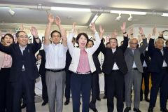 万歳をして初当選を喜ぶ湯浅氏（２０日午後９時２０分ごろ、新得町内の選対事務所で。金野和彦撮影）