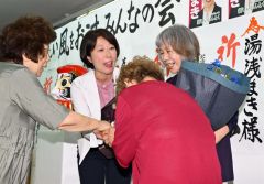支援者から花束を受け取る湯浅氏。右は母親の貴志子さん（２０日午後９時１５分ごろ、新得町内の選対事務所で。金野和彦撮影）