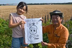 小麦畑に描く巨大アートのデザインを紹介する三浦農場の三浦代表（右）とデザインを考案した東士幌小の佐藤さん（左）