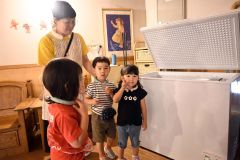 冷凍庫から取り出したクールネックリングを園児に掛ける看護師の佐藤さん